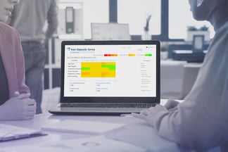 Отчёт Team Diagnostic Survey с тепловой картой по нескольким командам на экране ноутбука